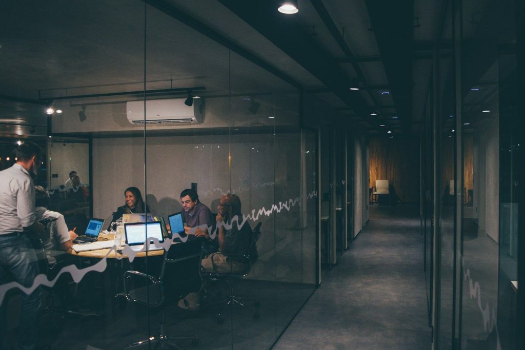 Grupo de profesionales trabaja de noche en una oficina vidriada